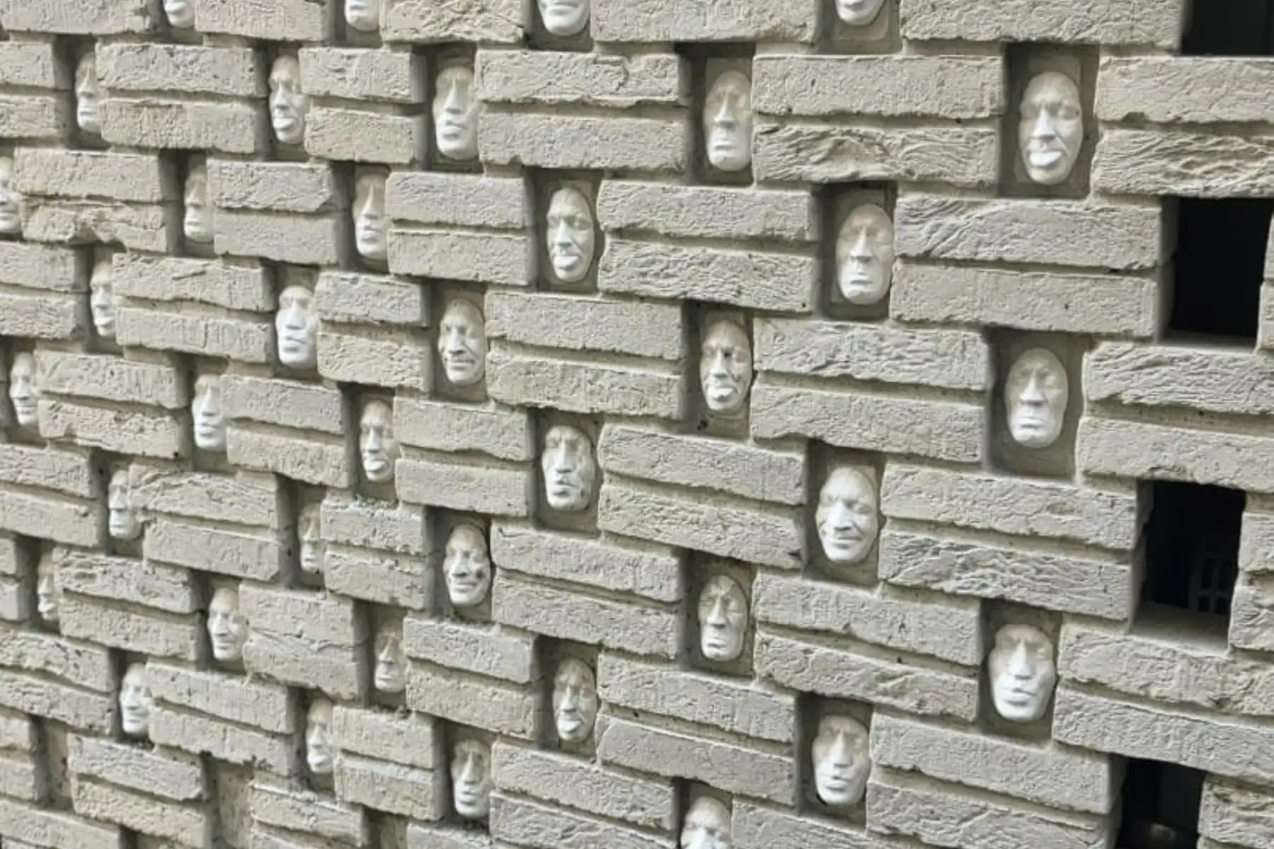 Visages sculptés dans un mur de pierre